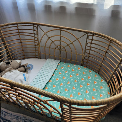 green fox baby blanket, mint minky backing, 100% organic cotton in a bassinet