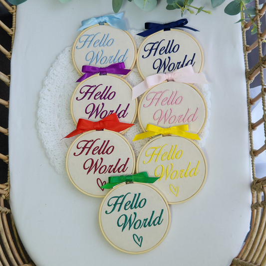 hello world embroidered baby announcement discs, blue, navy, purple, pink, red, yellow and green with bow